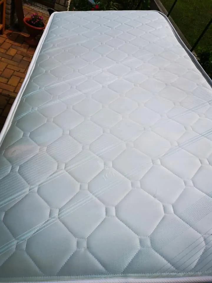 The quilted mattress photographed outdoors after cleaning from a different angle